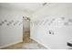 Well-lit laundry room features white tile with gray accents and in-unit hookups at 6212 N Grady Ave, Tampa, FL 33614