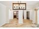 Bright open-concept living area with elegant tile flooring, stylish lighting, and decorative columns around the space at 6212 N Grady Ave, Tampa, FL 33614