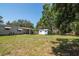The lush backyard features an outbuilding, open area, and mature trees for shade and privacy at 6226 Florence St, Gibsonton, FL 33534