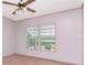 A neutral bedroom featuring two windows and a ceiling fan at 6226 Florence St, Gibsonton, FL 33534