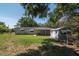 Exterior backyard shot of house with porch, outbuilding, and abundant greenery at 6226 Florence St, Gibsonton, FL 33534