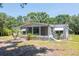 Charming home featuring a screened-in porch and lush landscaping at 6226 Florence St, Gibsonton, FL 33534