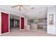 Spacious living room with ceiling fan flows into kitchen through doorway with red curtains at 6226 Florence St, Gibsonton, FL 33534