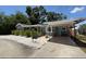 Charming home with a gray exterior, teal doors, covered parking, and white stone landscaping at 6741 4Th Ave N, St Petersburg, FL 33710