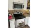 This kitchen features granite countertops, stainless steel microwave, and white wooden cabinets at 6741 4Th Ave N, St Petersburg, FL 33710