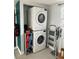 Stackable washer and dryer unit in laundry room with shelving and ladder at 6741 4Th Ave N, St Petersburg, FL 33710