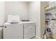 Functional laundry room with modern washer, dryer, and shelving offering convenience and organized storage at 7119 Amelia River Dr, Parrish, FL 34219