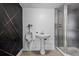 Retro bathroom featuring a pedestal sink, a glass door shower and a unique black and gold accent wall at 7137 Wedgewood Dr, New Port Richey, FL 34652