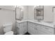 Bathroom featuring dual sinks, modern mirrors, and white cabinetry with black hexagon tile floor at 7137 Wedgewood Dr, New Port Richey, FL 34652