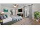 Nicely staged bedroom with ceiling fan, view of an en-suite bathroom through barn doors at 7137 Wedgewood Dr, New Port Richey, FL 34652