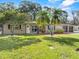 Charming single-story home featuring a green lawn, complemented by palm trees and a double car garage at 7137 Wedgewood Dr, New Port Richey, FL 34652