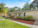 Lovely single-story home featuring a green lawn, complemented by mature trees and a charming pathway at 7137 Wedgewood Dr, New Port Richey, FL 34652