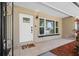 Welcoming front porch with a white door, tiled flooring, and views of lush landscaping at 7137 Wedgewood Dr, New Port Richey, FL 34652