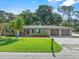 Charming single-story home featuring lush green lawn, mature trees, complemented by a double car garage at 7137 Wedgewood Dr, New Port Richey, FL 34652