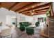 Inviting living room features exposed wood beams and a cozy green seating arrangement at 7137 Wedgewood Dr, New Port Richey, FL 34652
