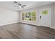 Bright living room features stylish flooring, ceiling fan and large window overlooking verdant landscaping at 7137 Wedgewood Dr, New Port Richey, FL 34652