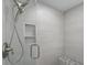 Modern shower with a glass door, stylish fixtures, a tiled bench and convenient storage shelf at 7137 Wedgewood Dr, New Port Richey, FL 34652