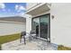 An open air back patio with two chairs, a view into the house through a sliding door, and some cleaning supplies at 7380 Sail Clover Ln, Zephyrhills, FL 33540