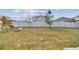 Green backyard featuring playset and white fence; perfect for Gathering activities and outdoor enjoyment at 7380 Sail Clover Ln, Zephyrhills, FL 33540