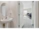 Clean, well-lit half-bath with a pedestal sink and access to other rooms at 7380 Sail Clover Ln, Zephyrhills, FL 33540