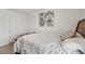 Comfortable bedroom featuring a decorative painting, neutral tones, and plush bedding at 7380 Sail Clover Ln, Zephyrhills, FL 33540