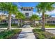 Paver sidewalk leading through the clubhouse entrance framed with palm trees and decorative stone at 7380 Sail Clover Ln, Zephyrhills, FL 33540
