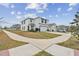 Wide view of a two-story, white modern home with a two-car garage at 7380 Sail Clover Ln, Zephyrhills, FL 33540