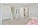 Upstairs hallway features a bathroom, bedrooms, and a view of the home's bright interior at 7380 Sail Clover Ln, Zephyrhills, FL 33540