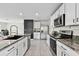 Well-lit kitchen featuring stainless steel appliances, granite countertops, and ample cabinet space at 7380 Sail Clover Ln, Zephyrhills, FL 33540