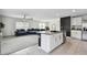 Open concept living area with modern kitchen island and a large sectional sofa at 7380 Sail Clover Ln, Zephyrhills, FL 33540