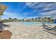 Community pool surrounded by lounge chairs, palm trees, and a black fence at 7380 Sail Clover Ln, Zephyrhills, FL 33540