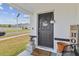 Charming front porch with a welcome sign, potted plants and a 'Welcome to our Home' sign at 7380 Sail Clover Ln, Zephyrhills, FL 33540