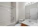 Bright bathroom featuring a shower-tub combo and a sink with a wooden cabinet at 7412 Bridgeview Dr, Wesley Chapel, FL 33545