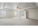 A large, carpeted bedroom with a tray ceiling and an en suite bathroom at 7412 Bridgeview Dr, Wesley Chapel, FL 33545