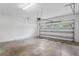 Spacious garage features concrete floors, overhead lighting, and a roll-up door with window panels at 7412 Bridgeview Dr, Wesley Chapel, FL 33545