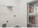 Convenient laundry room with shelving and utility connections, located near the kitchen at 7412 Bridgeview Dr, Wesley Chapel, FL 33545
