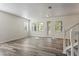 Bright living room with wood floors, large windows, and a decorative front door at 7412 Bridgeview Dr, Wesley Chapel, FL 33545