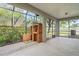 Enclosed patio features a brick grill, concrete flooring, and screened openings to a landscaped yard at 7412 Bridgeview Dr, Wesley Chapel, FL 33545
