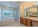 Well-lit bathroom with a soaking tub, separate shower, and dual vanities at 7852 Stoney Hill Dr, Wesley Chapel, FL 33545