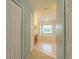 Hallway view leading to a bright bathroom with a soaking tub and natural light at 7852 Stoney Hill Dr, Wesley Chapel, FL 33545