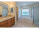 Bright bathroom showcasing a soaking tub with a window and a glass-enclosed shower at 7852 Stoney Hill Dr, Wesley Chapel, FL 33545