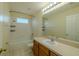 This bathroom features a shower-tub combo, large mirror, and a wood vanity at 7852 Stoney Hill Dr, Wesley Chapel, FL 33545