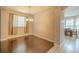 Cozy dining room features hardwood floors, a modern chandelier, and a large window that brightens the room at 7852 Stoney Hill Dr, Wesley Chapel, FL 33545