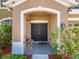 Close-up of a double front door with an arched entrance, framed by lush landscaping and charming details at 7852 Stoney Hill Dr, Wesley Chapel, FL 33545