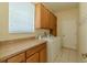 This laundry room has wooden cabinets, a countertop, a window, a washer, and a dryer at 7852 Stoney Hill Dr, Wesley Chapel, FL 33545
