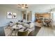 Open-concept living space with modern decor, hardwood floors, and a view of the adjacent kitchen and dining area at 7852 Stoney Hill Dr, Wesley Chapel, FL 33545