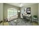 This office features a large window, decorative art, and a modern desk with office chair at 7852 Stoney Hill Dr, Wesley Chapel, FL 33545