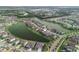 An aerial view showcases the property's enviable location on a lake with private backyard and verdant lawn at 7912 Yale Harbor Dr, Wesley Chapel, FL 33545