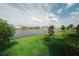 Scenic backyard view featuring a well-maintained lawn and a tranquil lake at 7912 Yale Harbor Dr, Wesley Chapel, FL 33545