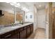 Bathroom featuring double sink vanity with granite countertop and a tiled shower with glass door at 7912 Yale Harbor Dr, Wesley Chapel, FL 33545